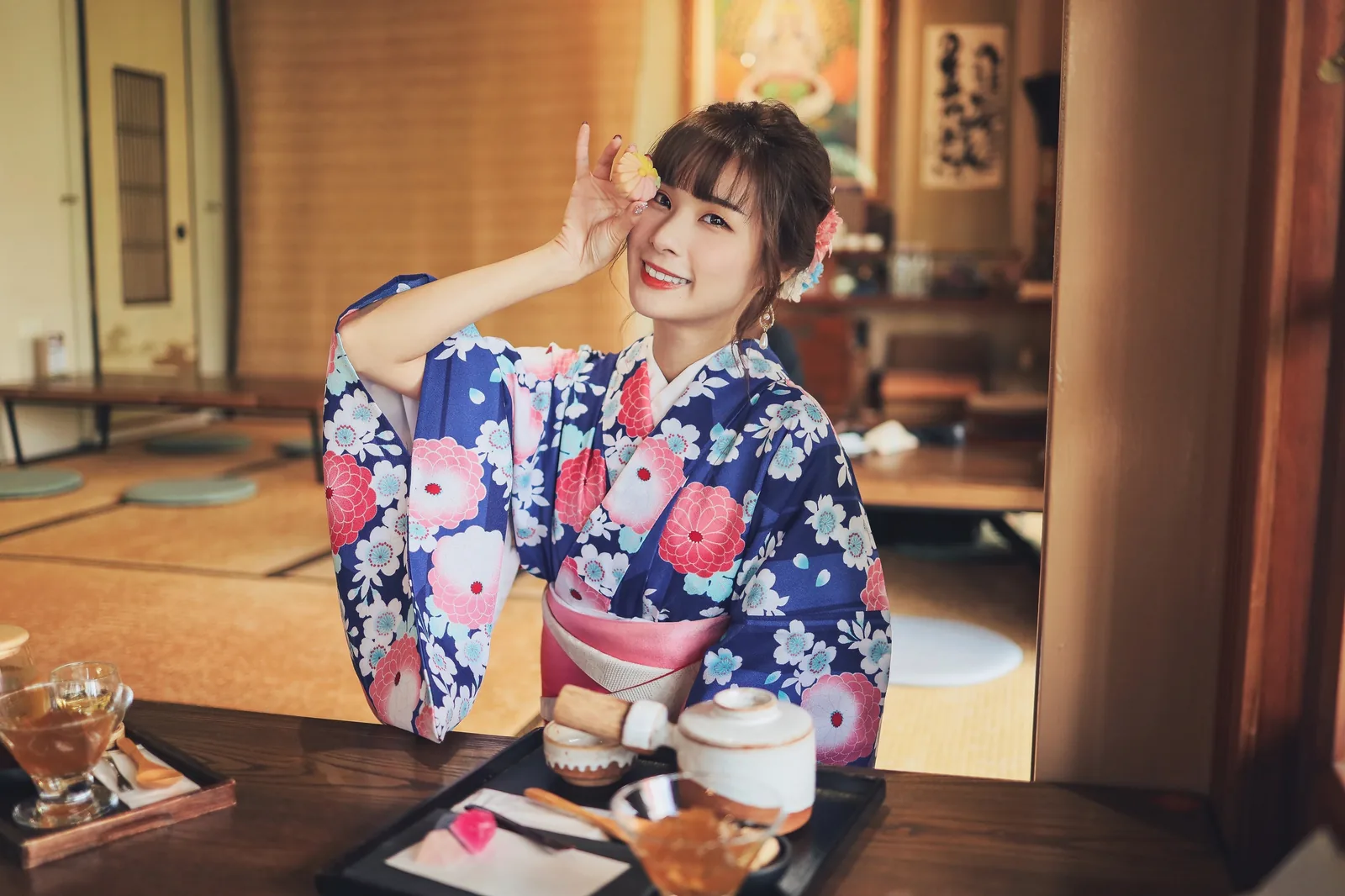 泥泥汝穿蓝底粉白花卉和风服装坐在茶点桌前